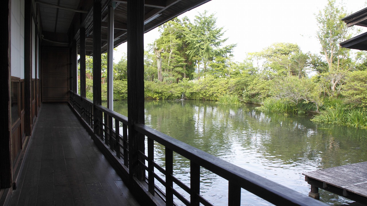水辺に沿って伸びる縁側。静かな光と揺れる水面が拡がる旧しらさぎ荘の風景