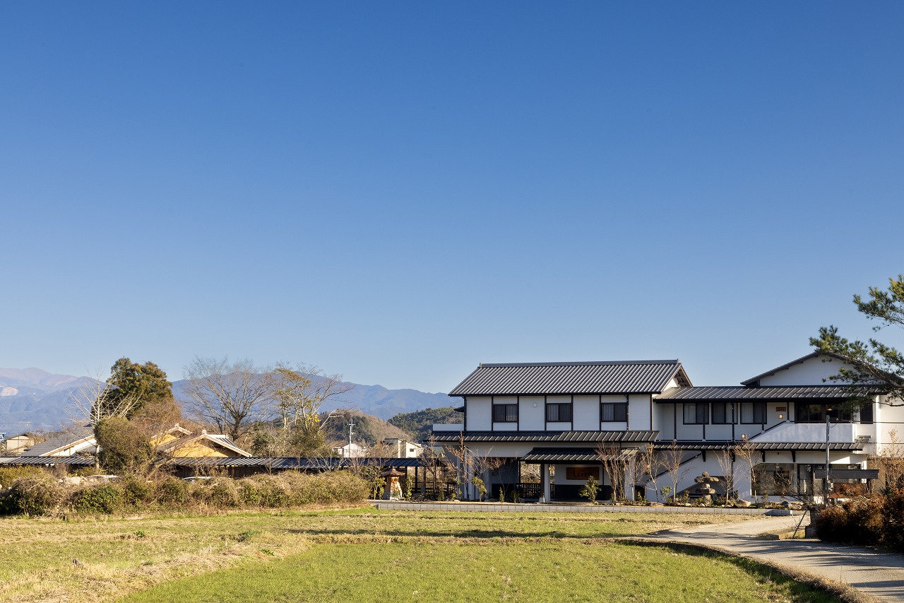 熊本県人吉市、青空と田園風景の中に佇む人吉温泉しらさぎ荘の外観