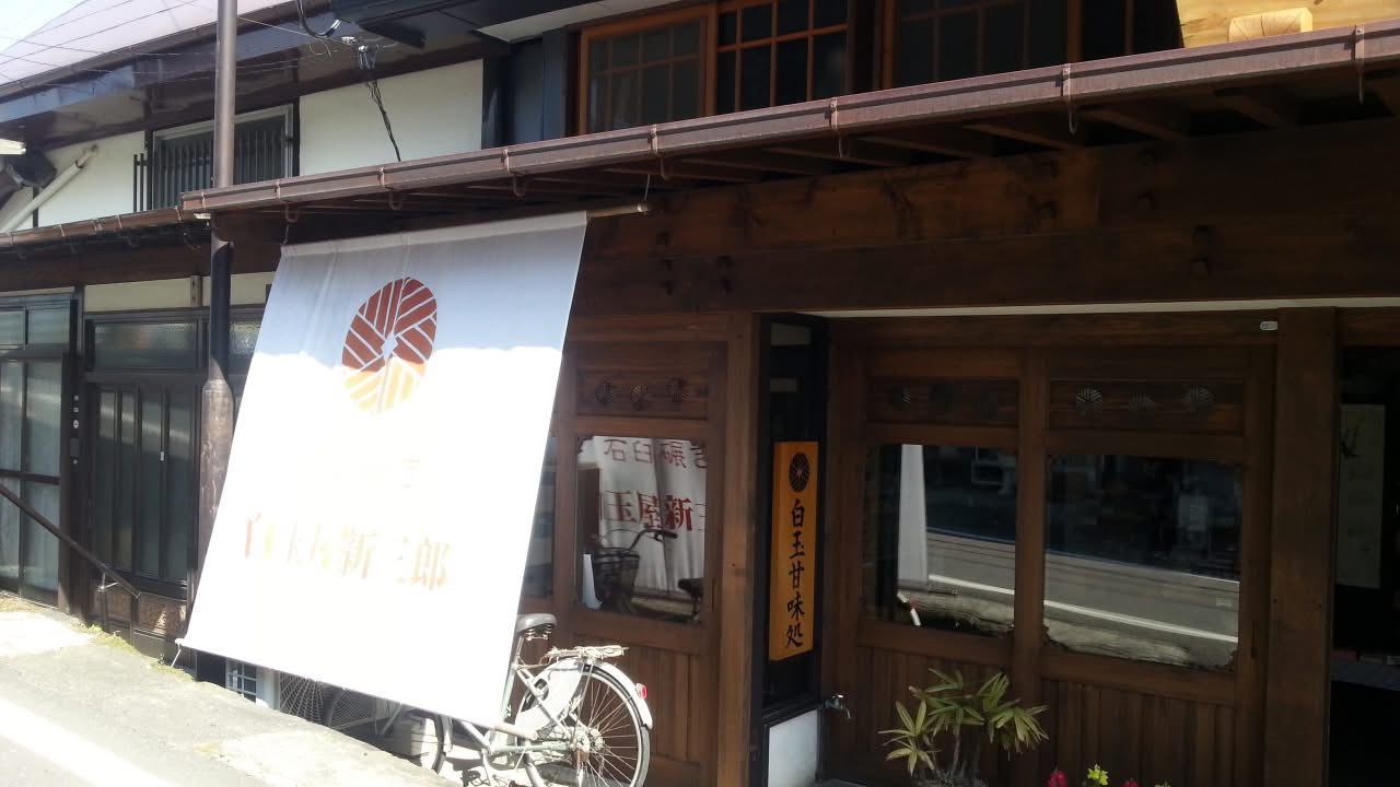地震前の白玉屋新三郎の店舗外観。暖簾がかかる落ち着いた佇まい。