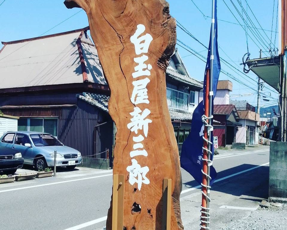 白玉屋新三郎の木製看板。店舗前に掲げられた歴史を感じる看板。